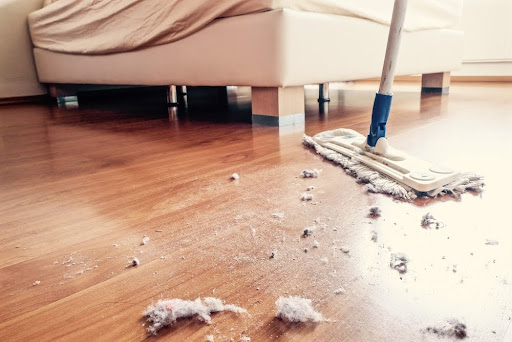Dust and dirt on a wooden floor in bedroom.